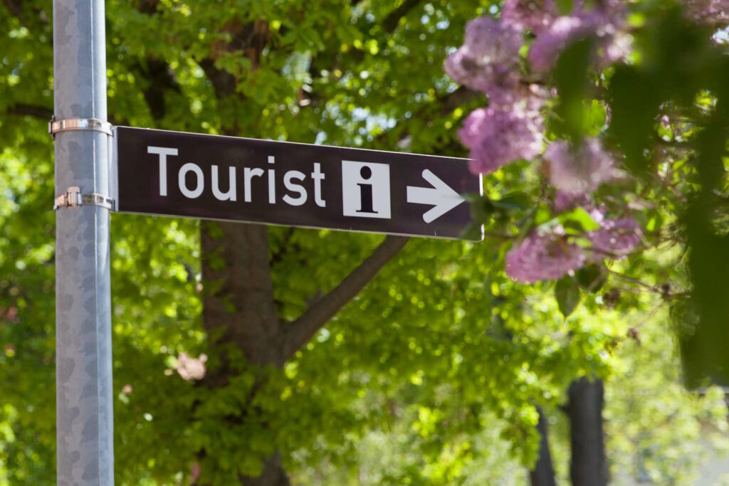 Tourist-Info Schild vor Bäumen