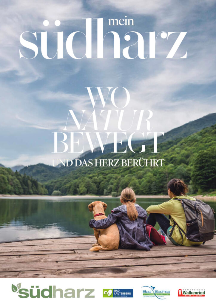 Titelbild des Südharz Magazin 2025. 2 Personen und ein Hund sitzten auf einem Steg und blicken auf einen See mit Bergen im Hintergrund.
